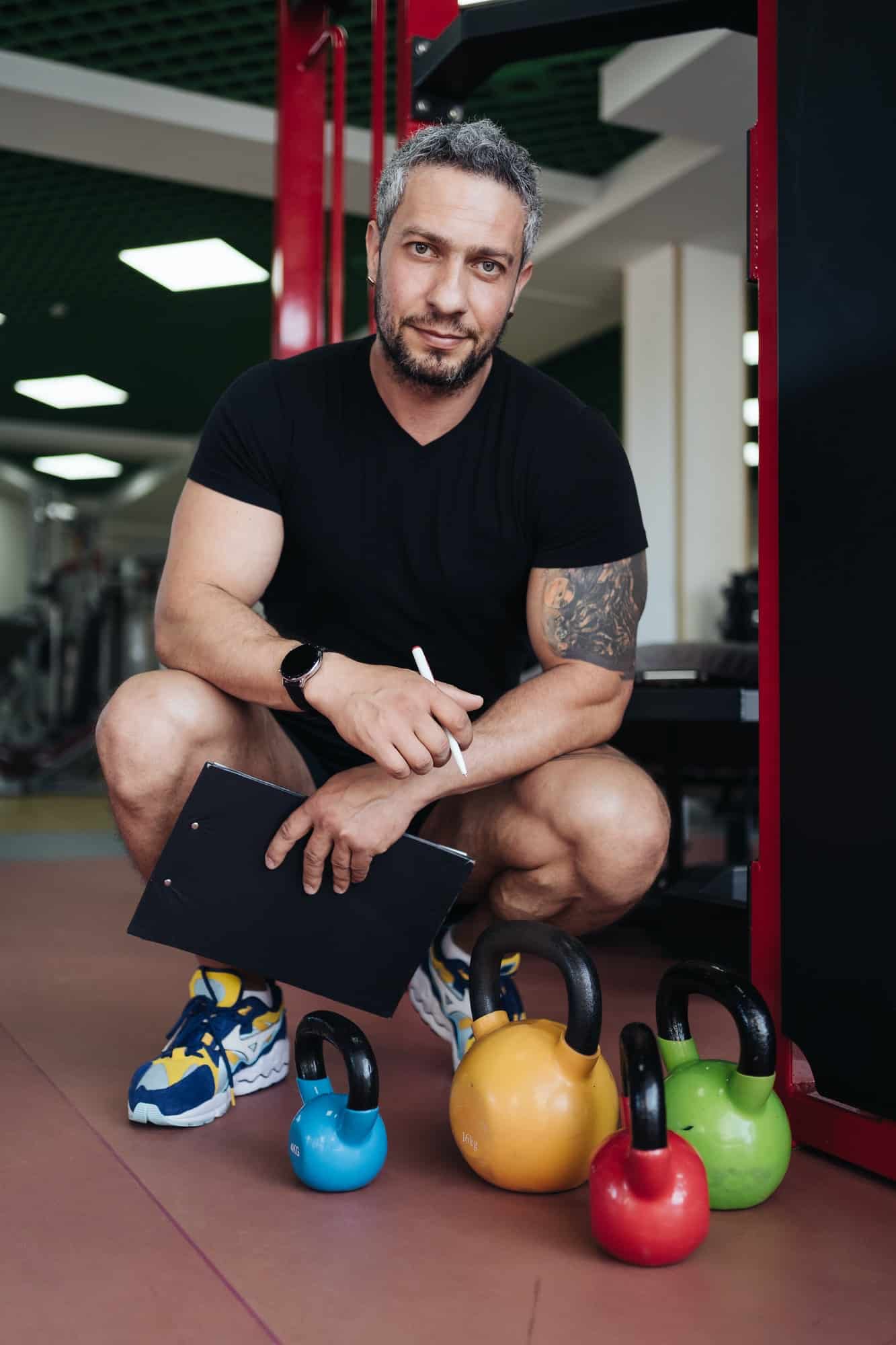 Personal fitness trainer writing a workout on gym background