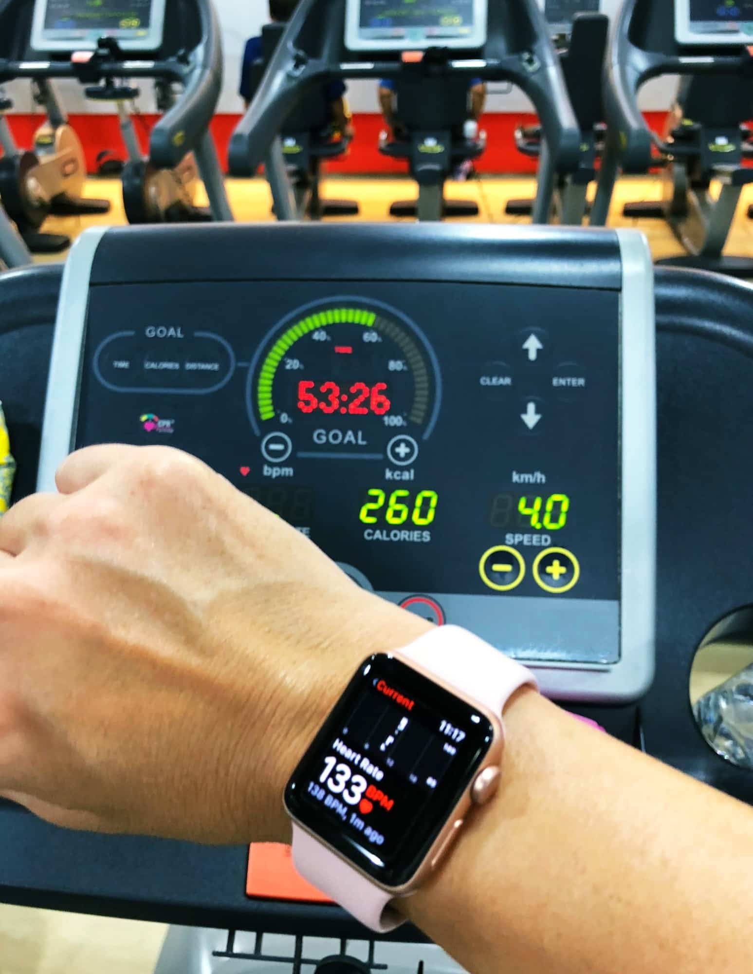 Woman look at exercise results on sport watch on wrist after running on thread mill in fitness club